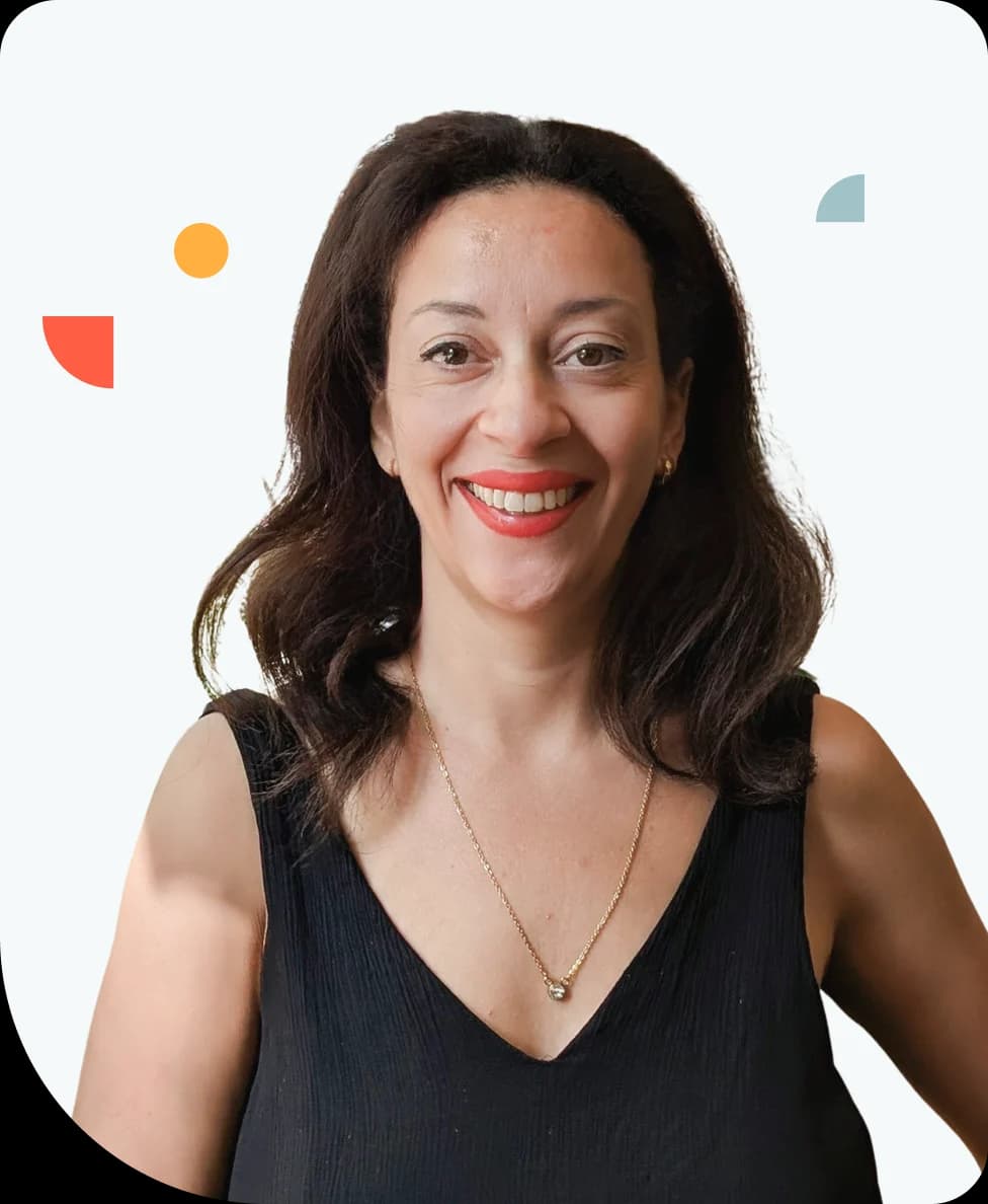 Smiling woman with long dark hair in a black sleeveless top, wearing a necklace, against a white background with colorful abstract shapes.